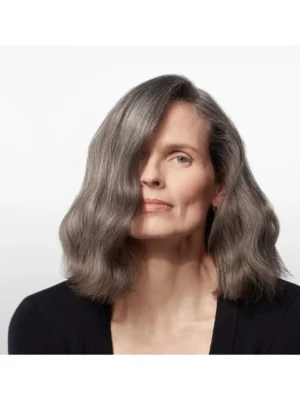 Modelo con cabello gris perfectamente hidratado y sedoso usando Oribe Supershine Moisturizing Cream.