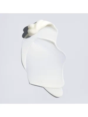 Muestra de la textura fluida y luminosa de la Oribe Supershine Light Moisturizing Cream sobre un fondo neutro.