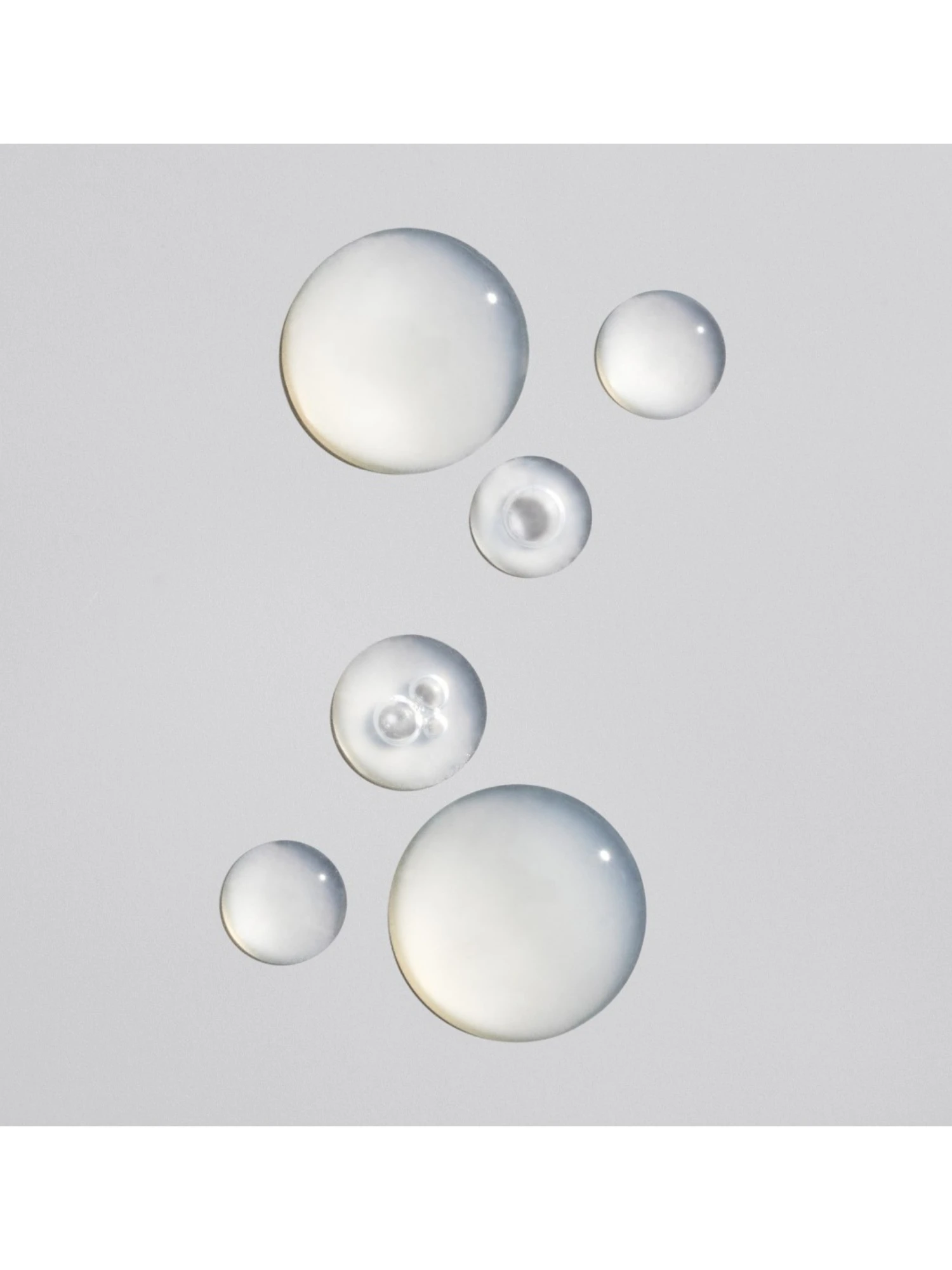 Detalle de las gotas traseras y transparentes del serum concentrado Oribe Power Drops Hydration & Anti-Pollution Booster.