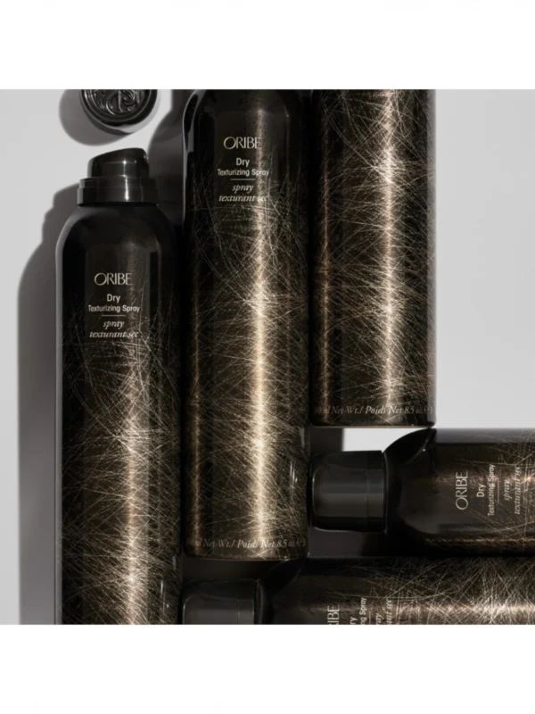 Composición artística de varios envases del spray texturizante en seco de Oribe