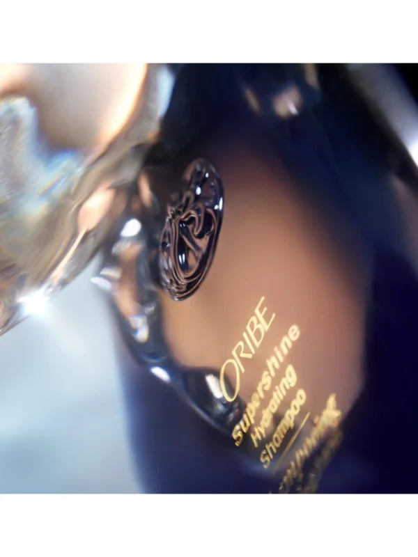 Detalle del emblema en relieve y letras doradas del Supershine Hydrating Shampoo.