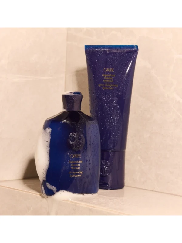 Set de Supershine Hydrating Shampoo y acondicionador en un estante de mármol.