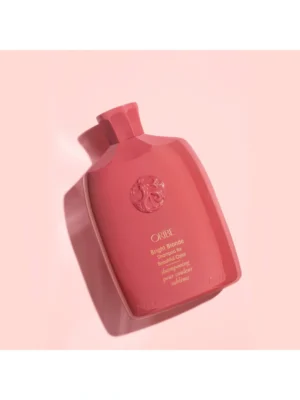 Presentación en bodegón de Oribe Bright Blonde Shampoo for Beautiful Color de 250 ml sobre fondo lila