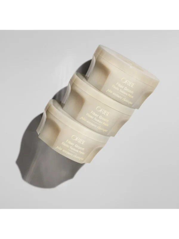 Composición profesional de Oribe Fiber Groom Elastic Texture Paste mostrando su diseño premium