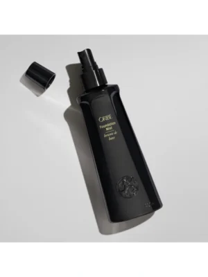 Detalle de Oribe Foundation Mist con el tapón abierto mostrando el pulverizador de precisión