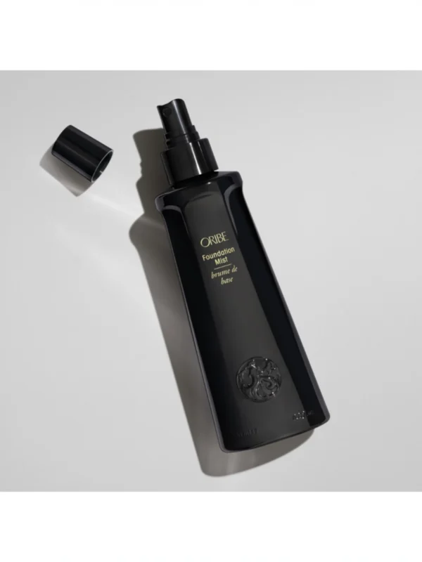 Detalle de Oribe Foundation Mist con el tapón abierto mostrando el pulverizador de precisión