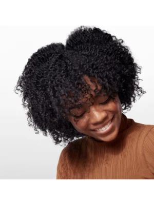 Modelo posando con cabello rizado nutrido y definido con Oribe Gold Lust Nourishing Hair Oil