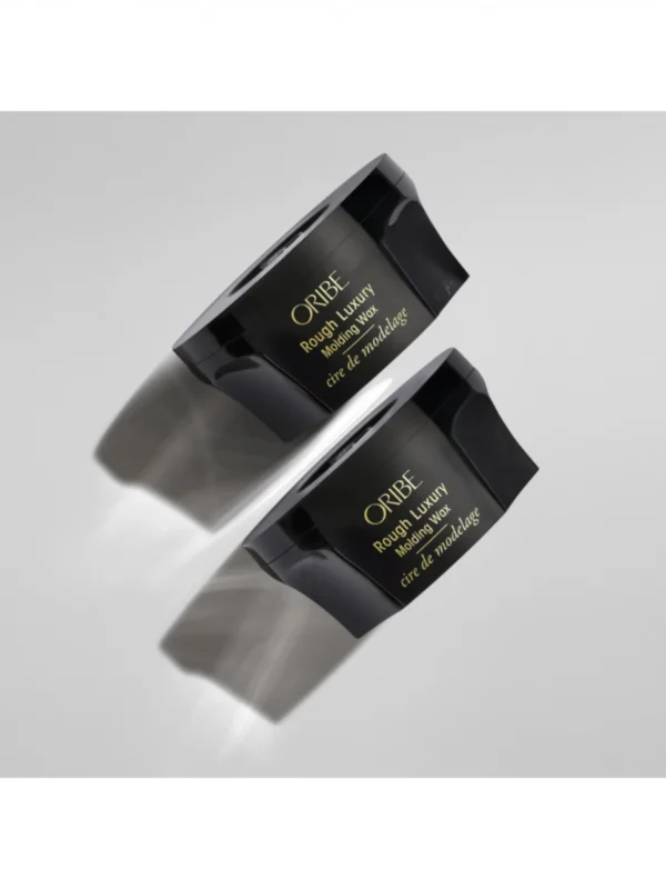 Dos botes de Oribe Rough Luxury Molding Wax en una composición estética con sombras suaves