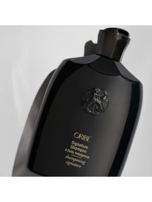 Envase del Oribe Signature Shampoo con diseño icónico y acabado premium