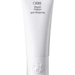 Tubo vertical de Oribe Silverati Conditioner en color blanco con el emblema circular en la base y letras negras sobre fondo blanco.