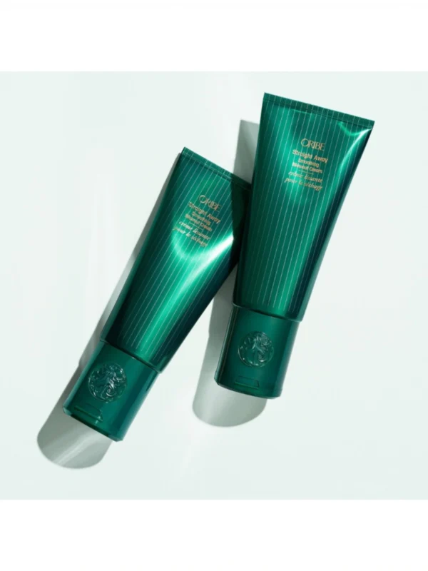 Composición de dos envases de Oribe Straight Away Smoothing Blowout Cream sobre fondo blanco con iluminación profesional