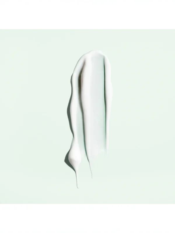 Detalle de la textura en crema fluida blanca de Straight Away Smoothing Blowout Cream sobre fondo verde claro