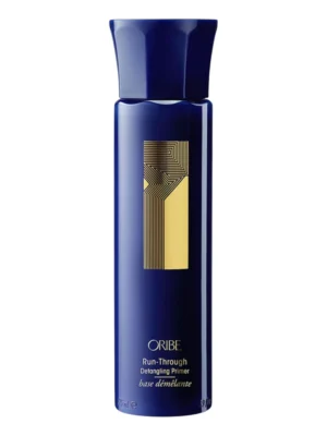 Envase vertical de Oribe Run-Through Detangling Primer con diseño minimalista y detalles dorados.