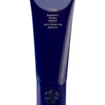 Envase azul elegante del Supershine Hydrating Conditioner de Oribe con tipografía dorada.