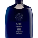 Frasco azul de Supershine Hydrating Shampoo de Oribe con detalles dorados.