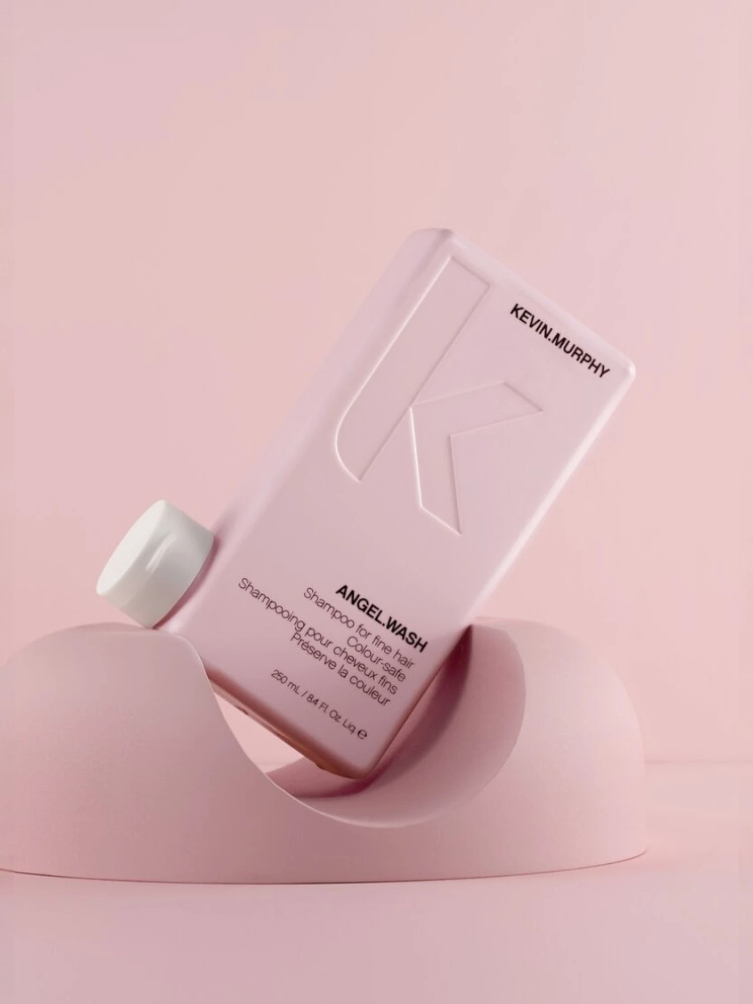 Kevin Murphy ANGEL WASH champú sobre fondo rosa con packaging minimalista