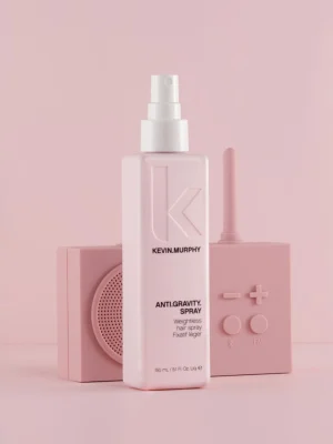 Kevin Murphy ANTI GRAVITY SPRAY spray ligero sobre fondo rosa con accesorios de styling