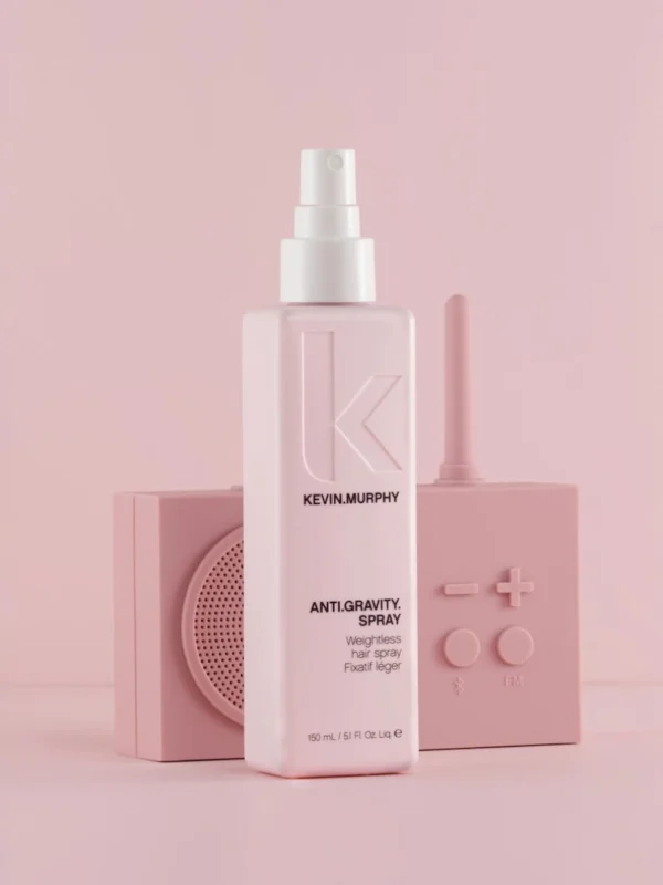 Kevin Murphy ANTI GRAVITY SPRAY spray ligero sobre fondo rosa con accesorios de styling