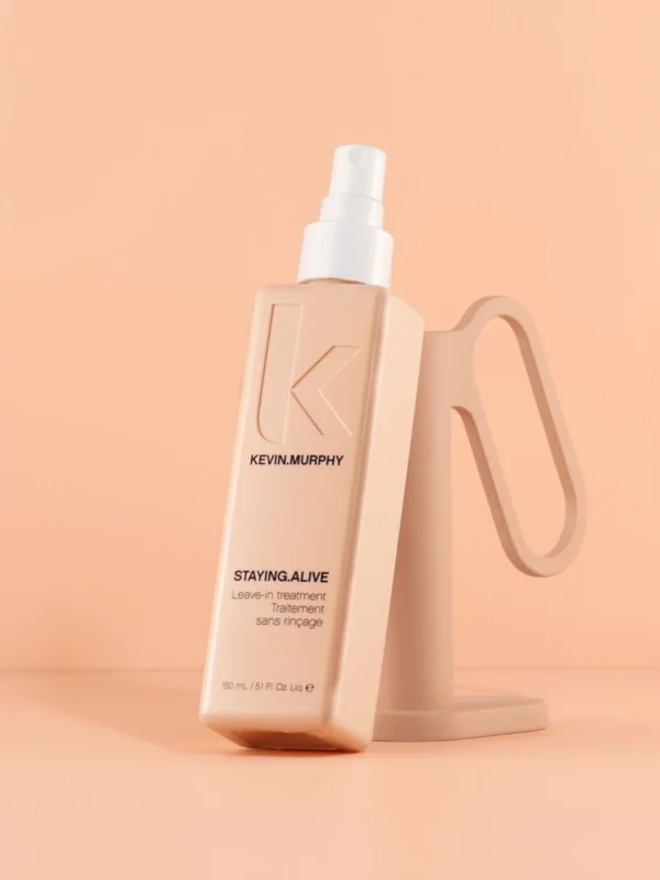 Kevin Murphy STAYING ALIVE spray leave in sobre fondo beige con packaging rosa