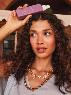 Modelo con cabello rizado usando Kevin Murphy UNTANGLED acondicionador leave-in desenredante