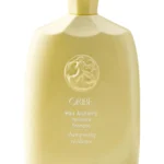 Champú fortalecedor Hair Alchemy de Oribe en envase original sobre fondo claro