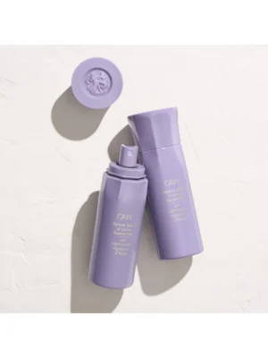Composición de dos frascos de Serene Scalp Oil Control Treatment Mist, uno con el tapón quitado mostrando el atomizador, sobre una superficie de piedra clara