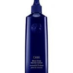 Botella frontal de Oribe Mirror Rinse Glass Hair Treatment en color azul marino brillante con aplicador de punta fina y emblema en relieve sobre fondo blanco.