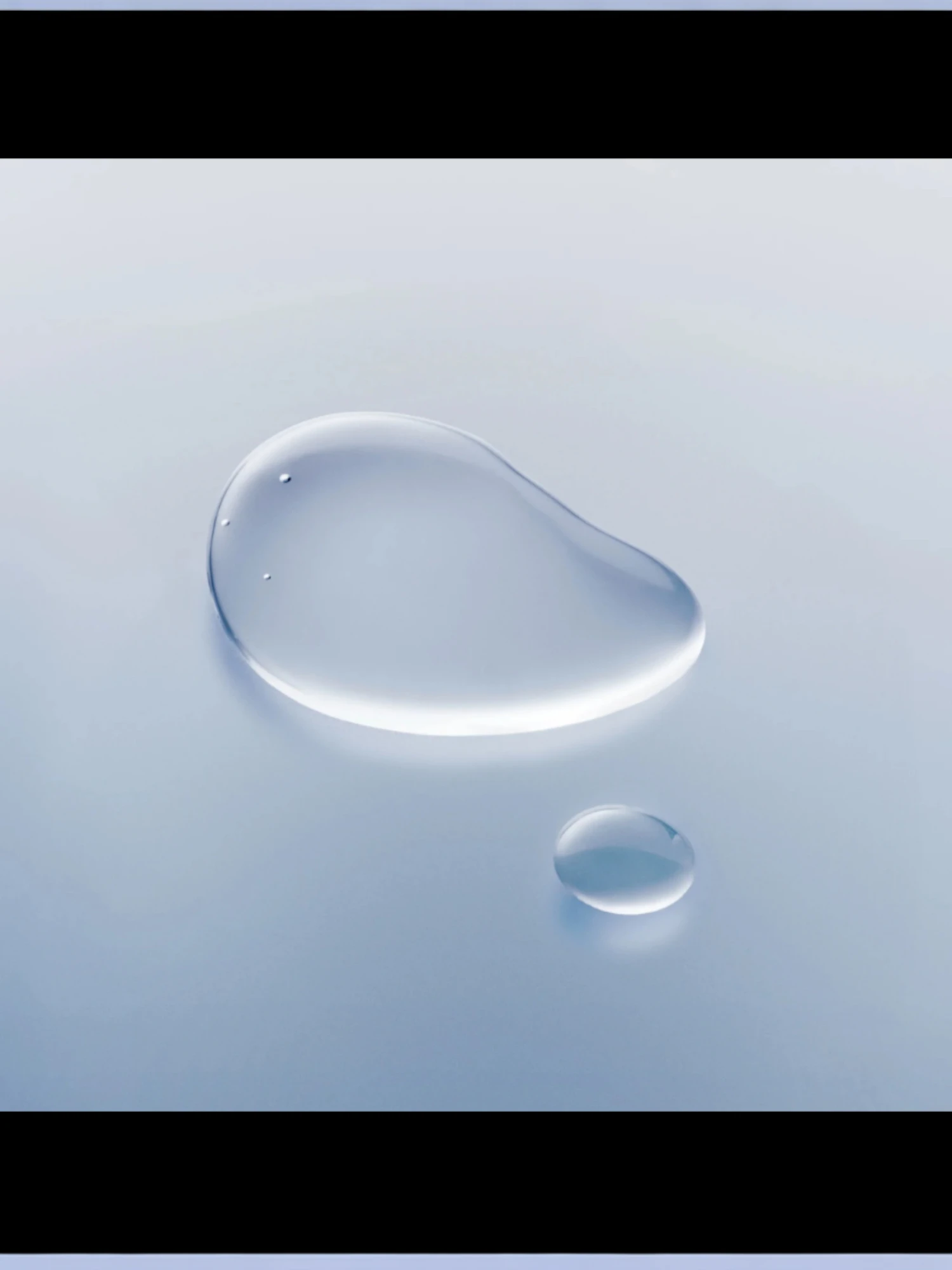 Muestra de la textura líquida, transparente y ligera del producto formando dos gotas cristalinas sobre una superficie azul claro difuminada.