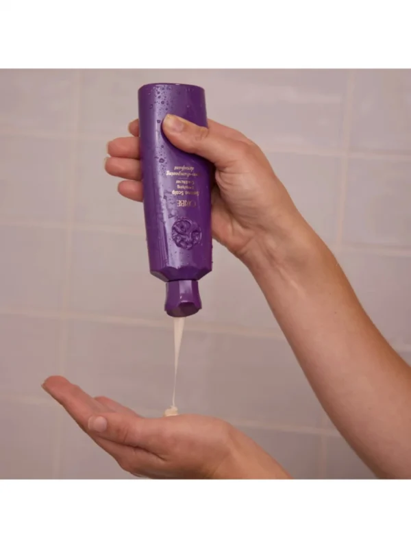 Aplicación del acondicionador Oribe Serene Scalp Densifying Conditioner durante el lavado