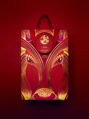 Detalle frontal de la bolsa de coleccionista del Hair Alchemy Liter Set con ilustraciones en rojos y dorados auspiciosos.