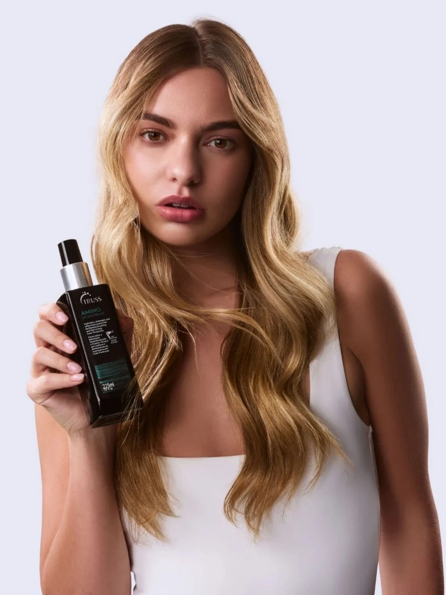 Modelo con cabello brillante usando Truss Amino protector térmico con efecto gloss