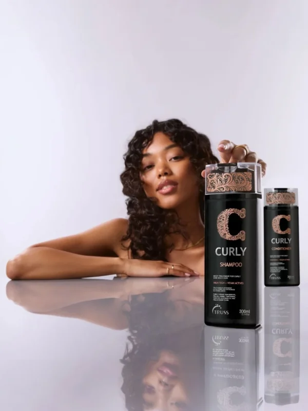 Modelo con cabello rizado junto a Truss Curly Shampoo y Conditioner