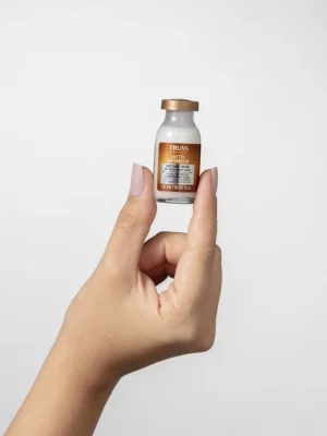 Ampolla Truss Instant Dose Nutri Infusion sostenida en la mano mostrando tamaño