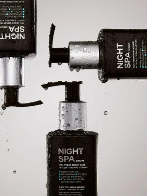 Detalle de envases Truss Night Spa con gotas de agua sobre fondo neutro