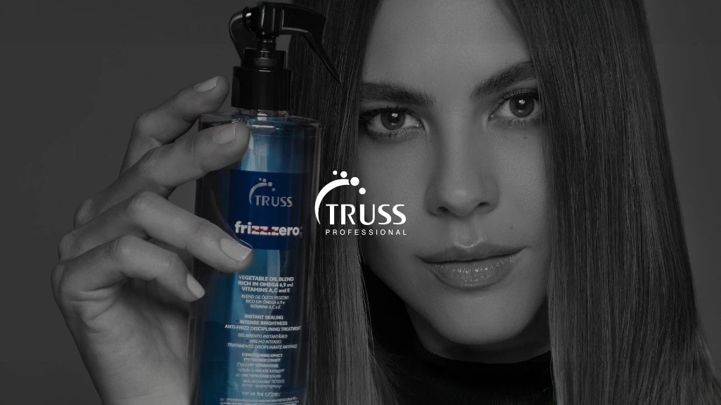 Modelo con cabello liso sosteniendo Truss Frizz Zero junto al logo Truss en Madrid