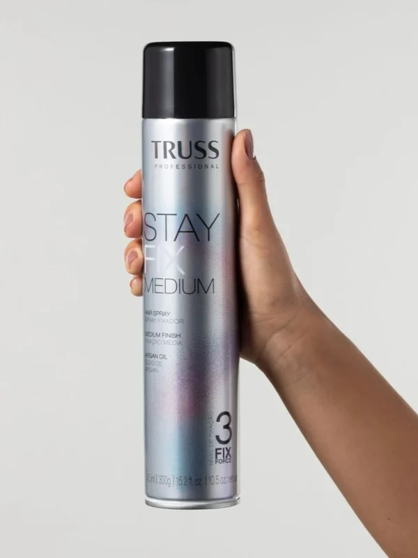 Mano sujetando laca Truss Stay Fix Medium 400 ml producto de fijación media