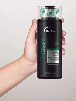 Truss Therapy Shampoo sostenido en la mano mostrando tamaño del envase